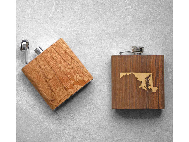 Two wooden flasks with map designs on a gray surface