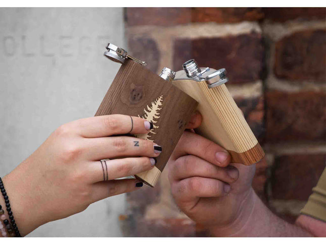 Two wooden guns held by hands against a brick wall.