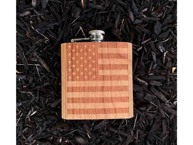 Wooden flask with American flag design on a bed of dark leaves