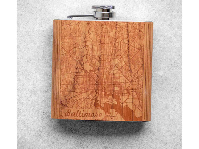 Wooden flask with engraved Baltimore map design on a gray background