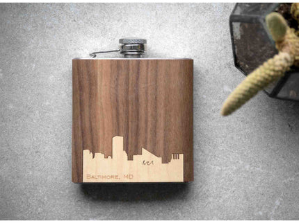 Wooden flask with laser-engraved city skyline on a gray surface