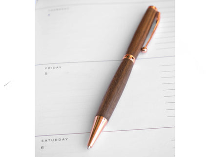 Wooden pen with rose gold accents on a planner
