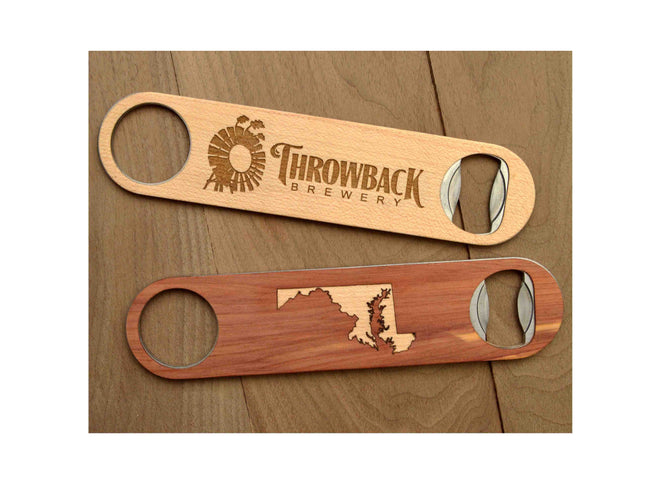 Two wooden bottle openers with engraved designs on a wooden surface