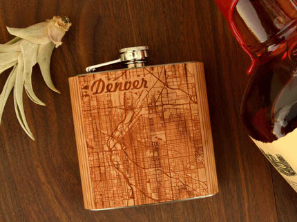 Wooden flask with engraved map design on a wooden surface
