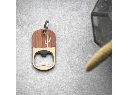 Wooden bottle opener keychain with cactus design on a gray surface