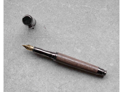Fountain pen with wooden grip on a gray surface