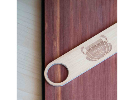Wooden journal with a wooden bottle opener on a wooden surface