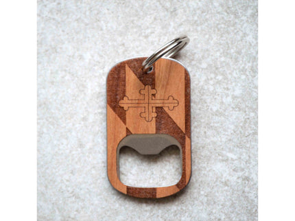 Wooden bottle opener keychain with a cross design on a textured surface