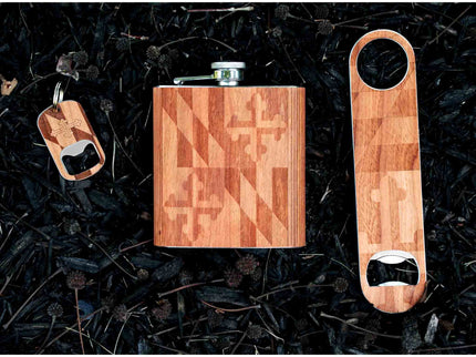 Wooden flask, keychain, and bottle opener set on a dark textured background