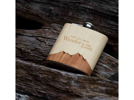 Wooden flask with engraved text on a wooden surface