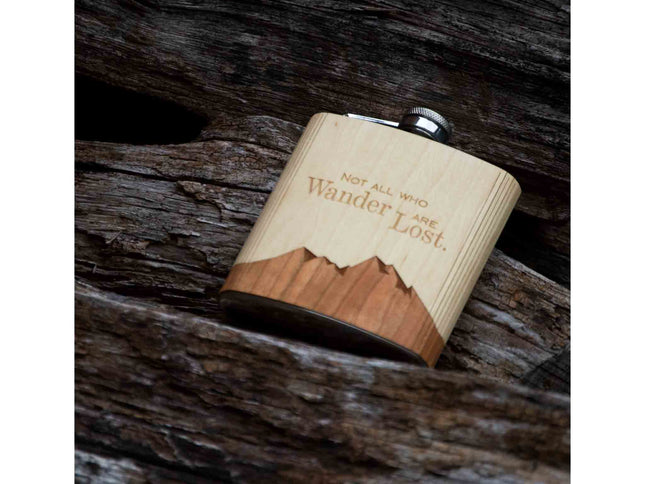 Wooden flask with engraved text on a wooden surface