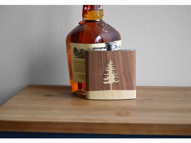 Bottle of whiskey with a wooden tumbler on a wooden surface