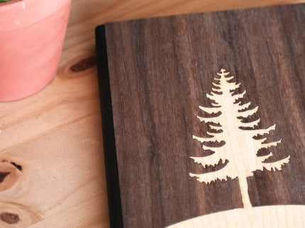 Wooden notebook with a tree engraving on a wooden surface