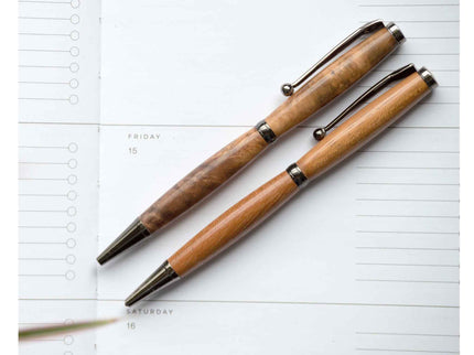 Two wooden pens on a planner page.