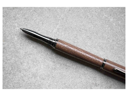 Pen with wooden barrel and metal clip on a gray background