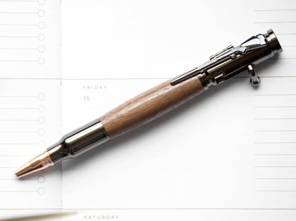 Black Walnut Bolt Action Pen by Autumn Woods, photographed against a white planner page